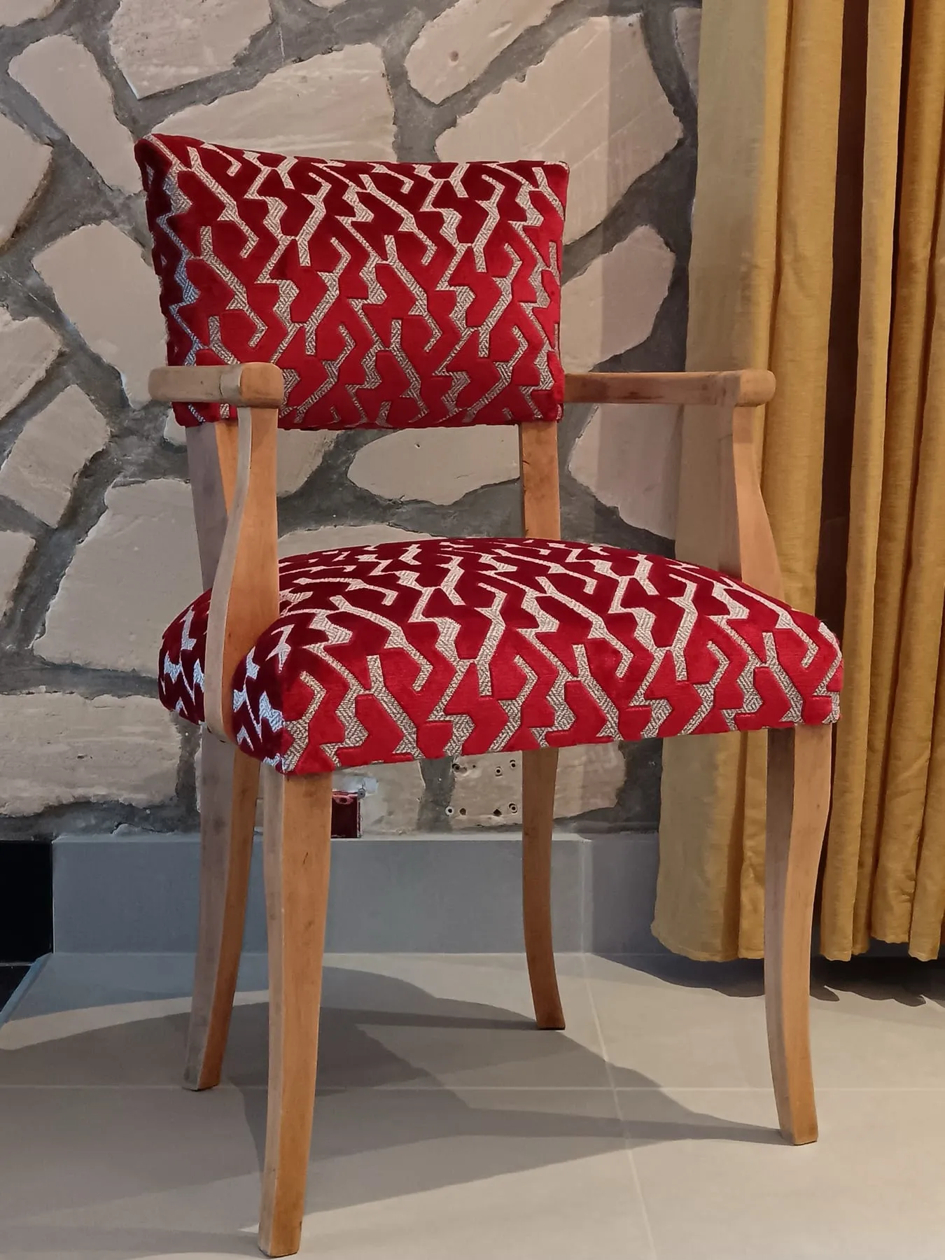 Fauteuil bridge recouvert d’un velours jacquard à motifs géométriques rubis et écru