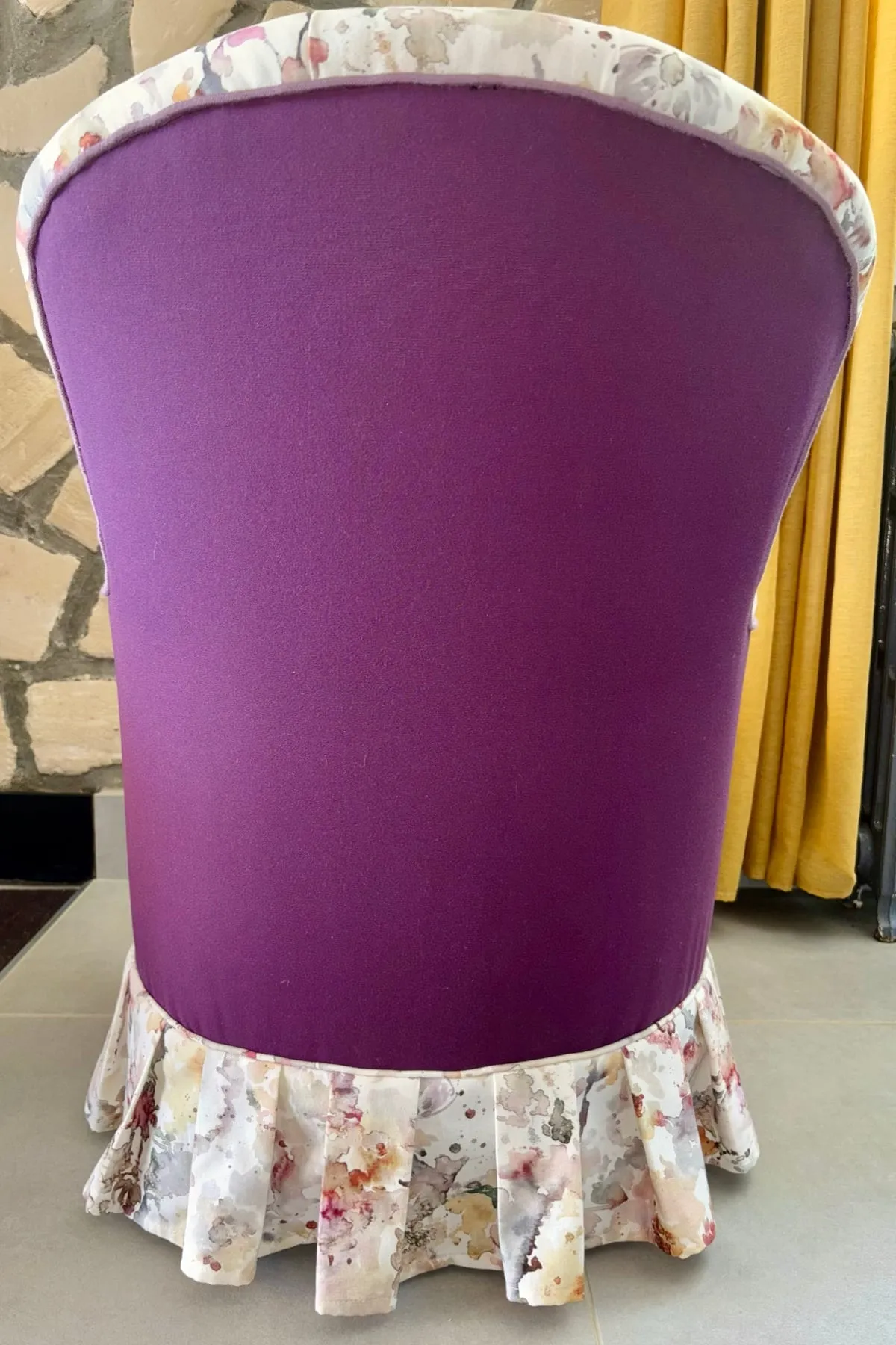Dos de la chauffeuse habillé d’un uni prune contrastant avec le tissu à motifs