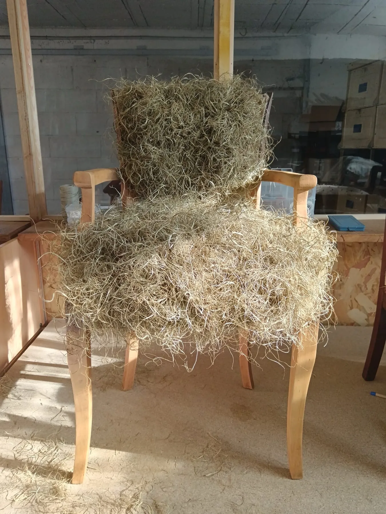 Crin végétal réparti sur une carcasse de fauteuil