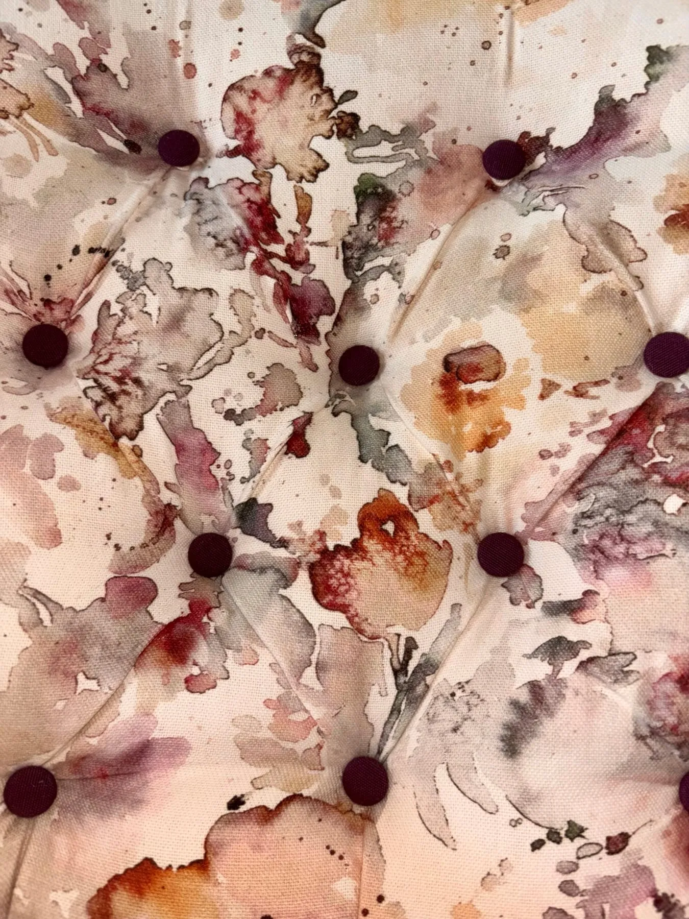 Gros plan des capitons boutonnés sur le tissu d’inspiration aquarelle