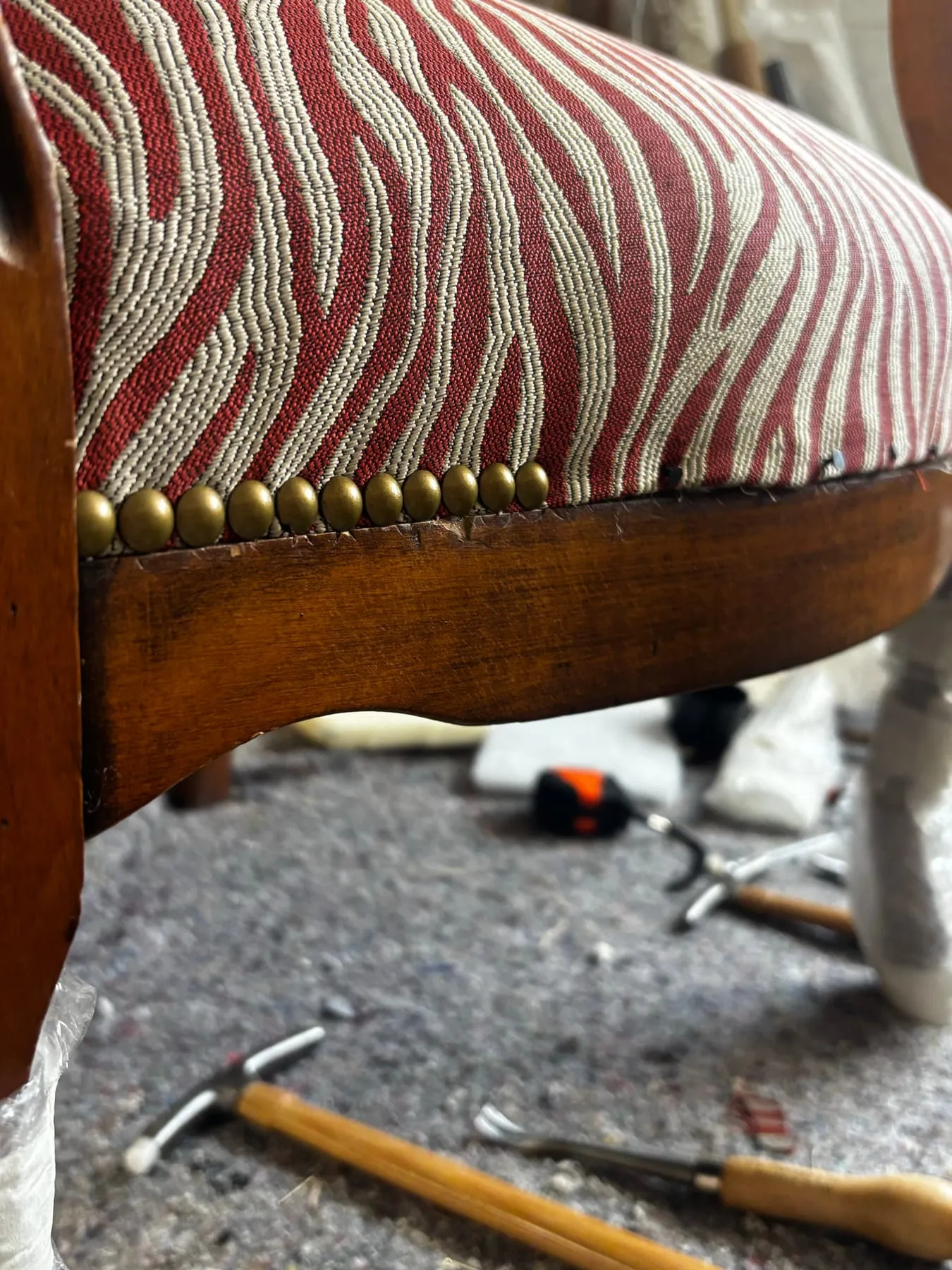 Gros plan des clous décoratifs posés le long de la ceinture du fauteuil