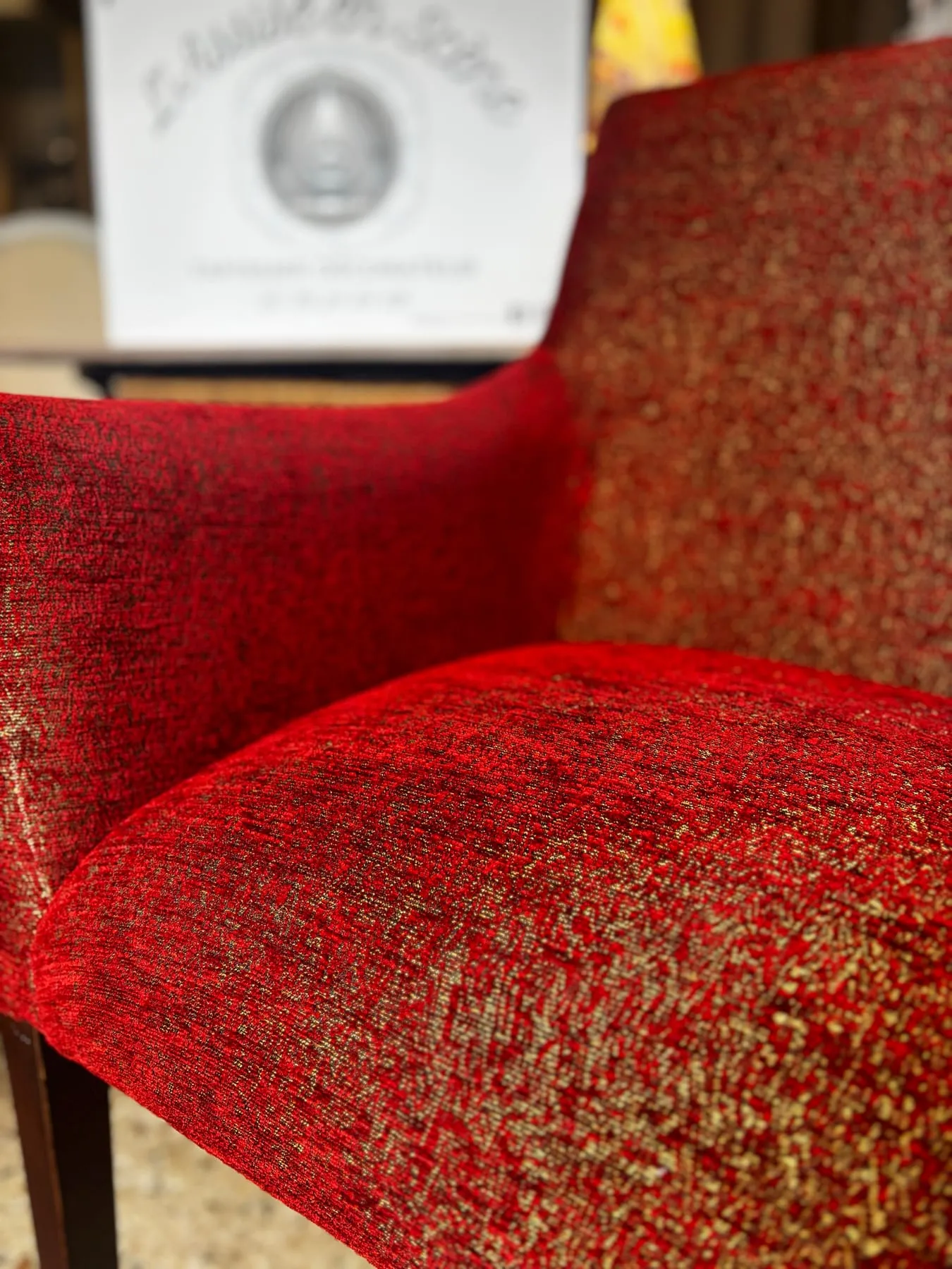 Détail de l’assise rebondie du fauteuil en chenille rouge