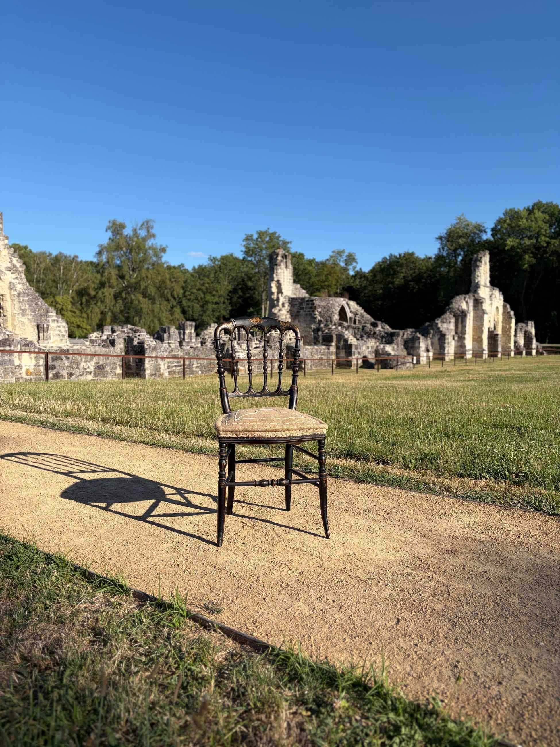 Chaise ancienne cannée posée devant les ruines d’une abbaye, dans l’Aisne