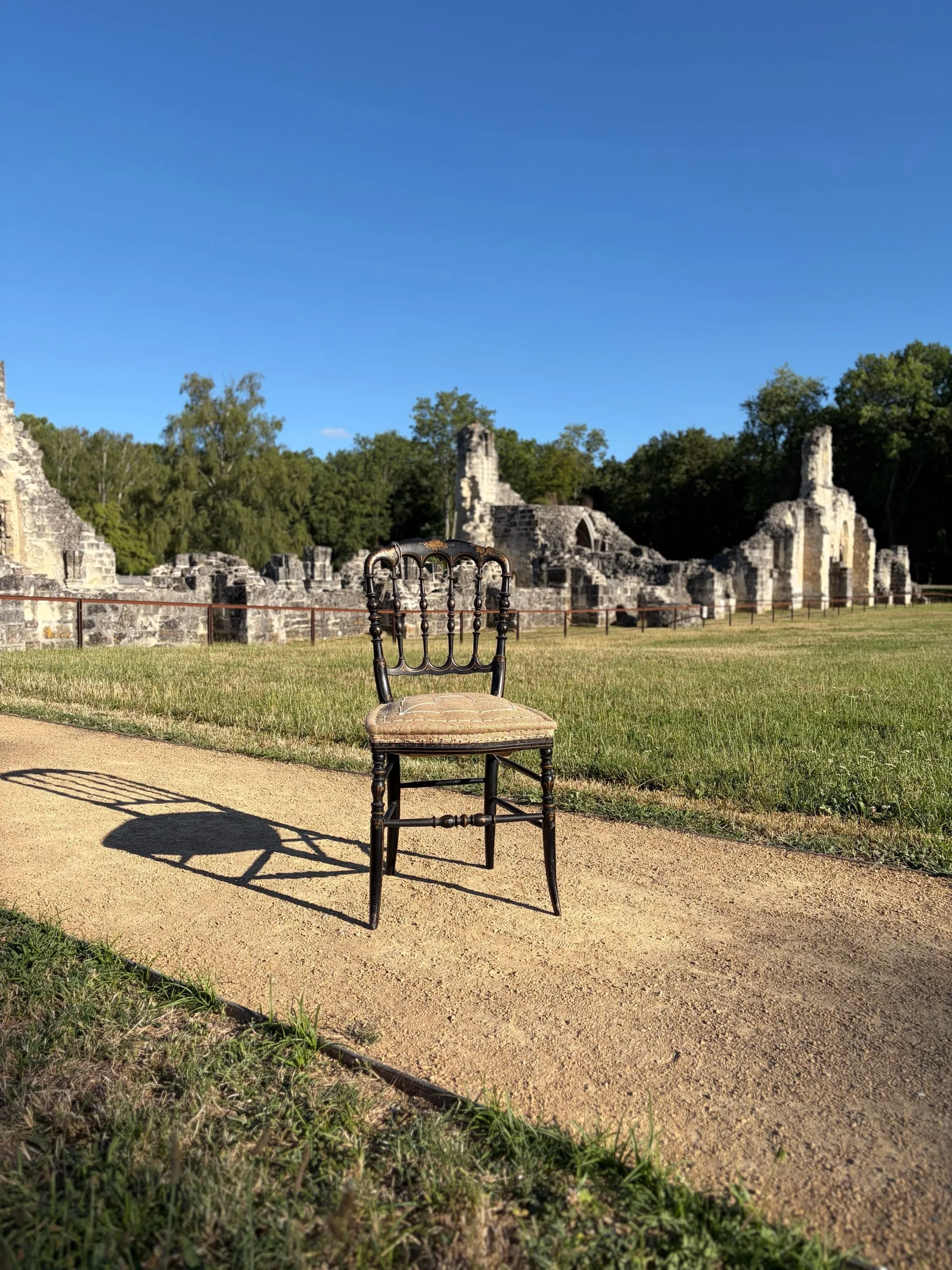 Chaise ancienne cannée posée devant les ruines d’une abbaye, dans l’Aisne