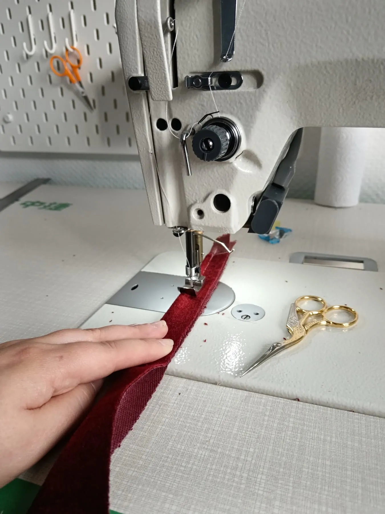 Machine à coudre de l’atelier en train de piquer un velours rouge