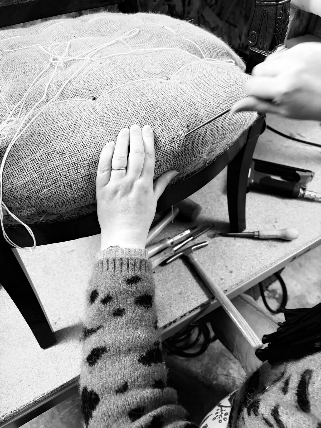 Mains mettant en forme la garniture de crin d’une assise