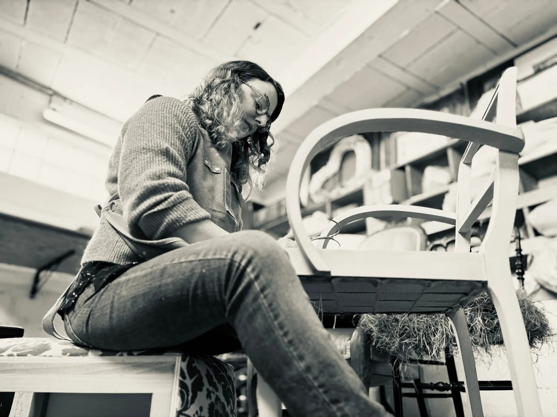 Perrine Wisniewski au travail sur une carcasse de fauteuil dans son atelier