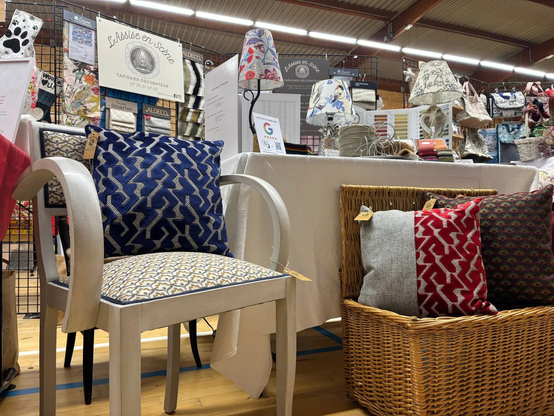 Coussins, chaises et abat-jour présentés dans l’espace de l’atelier