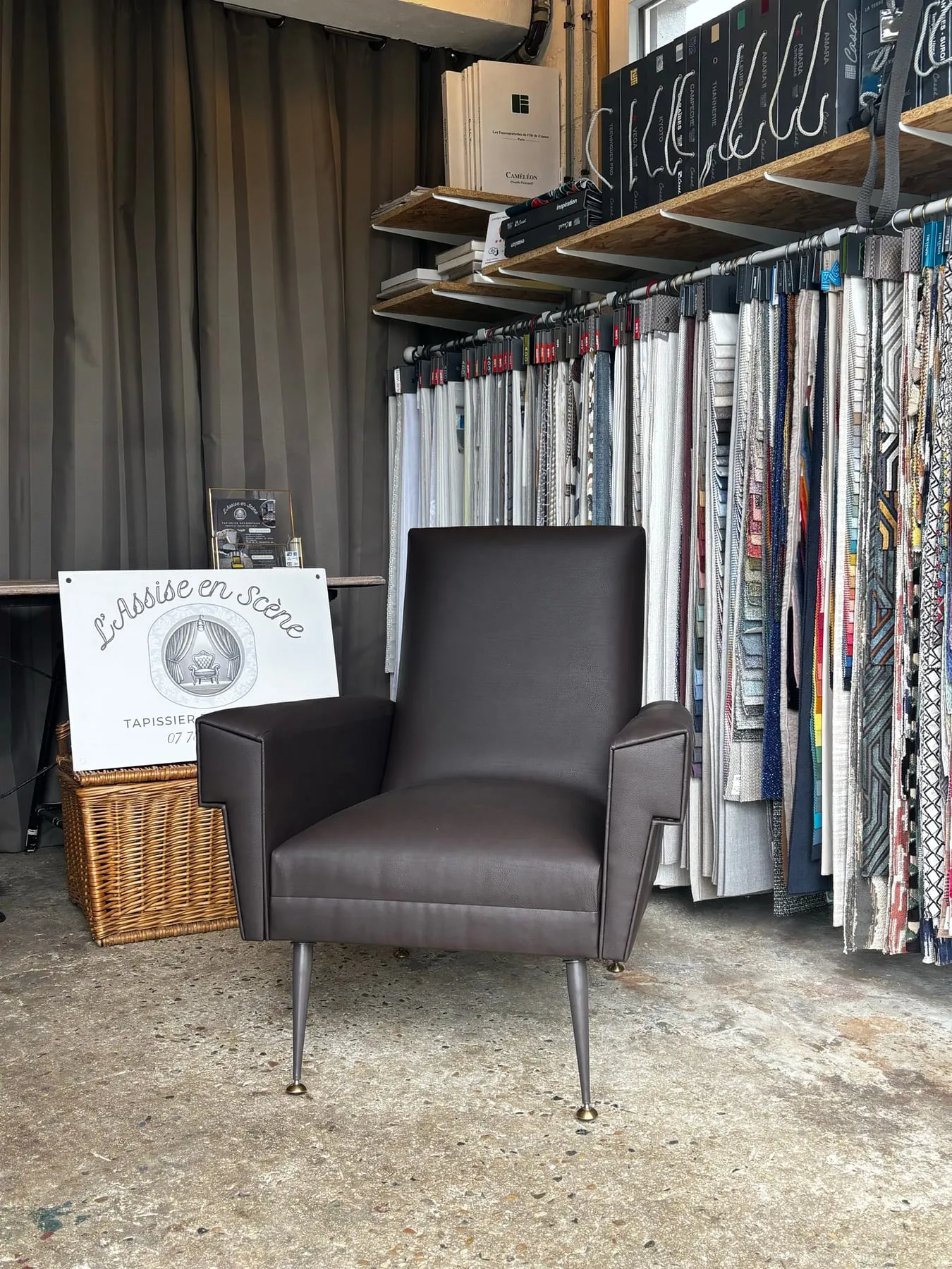 Espace de l’atelier avec les rouleaux de tissus d’éditeurs et un fauteuil terminé