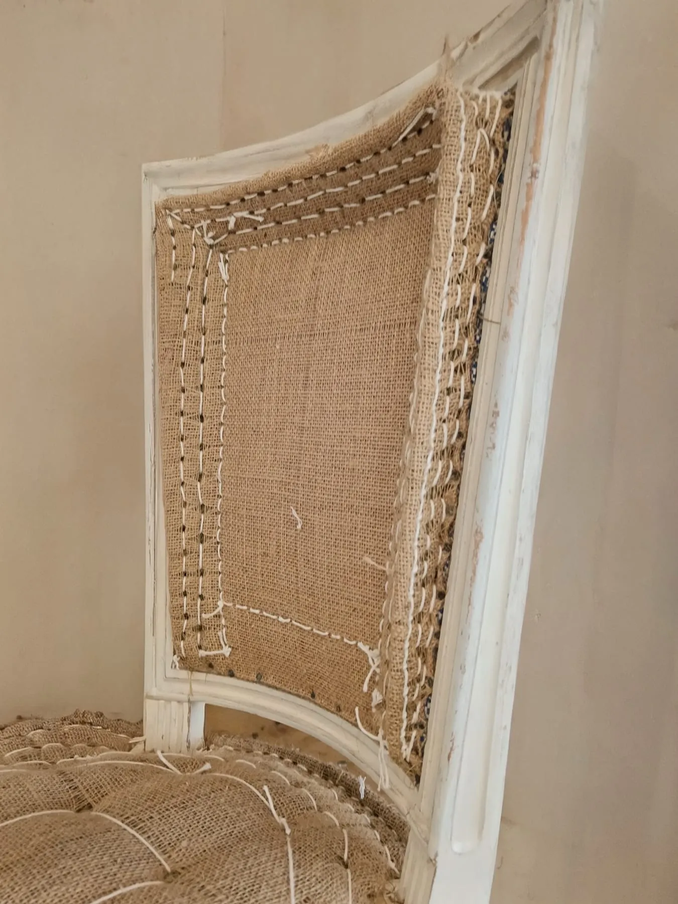 Toile de jute tendue et cousue sur un dossier de fauteuil